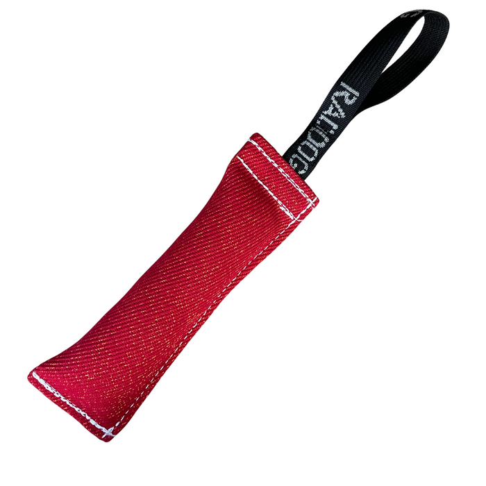 Red dog training tug toy with a durable textured fabric bite area, reinforced white stitching, and a black loop handle labeled “RADDOG,” isolated on a white background.