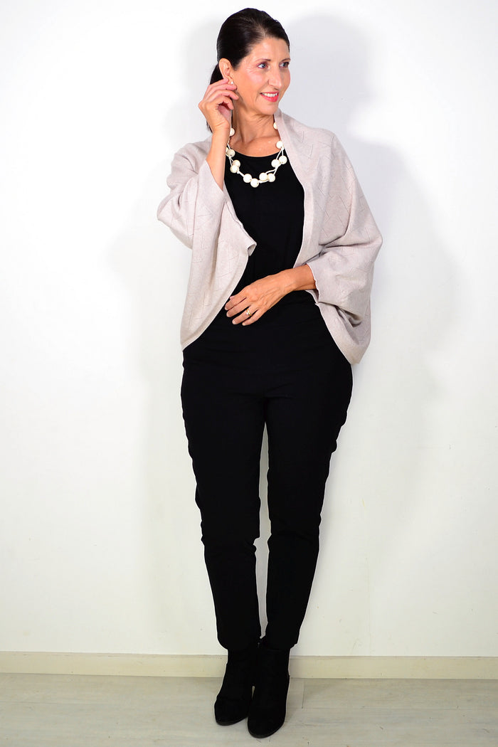 Beige Peony travel cardigan wrap draped over a chair, soft and cozy with a relaxed fit, perfect for travel and casual wear.