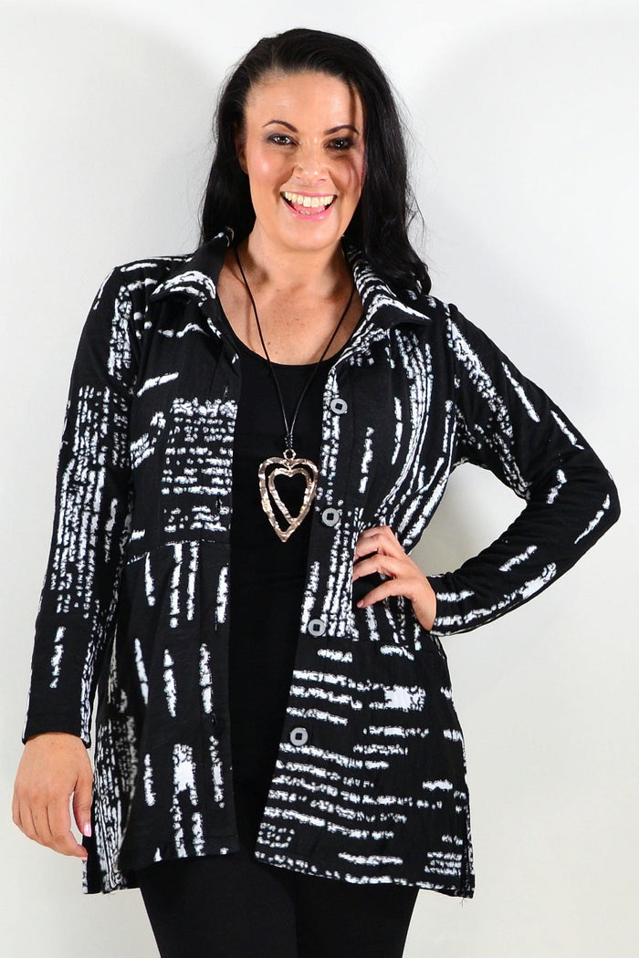 Black and white shirt jacket tunic by Hourglass displayed on a hanger, featuring a classic collar and button-front design.