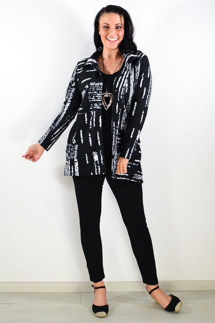 Black and white shirt jacket tunic by Hourglass, shown hanging with a tailored fit and button front detail.