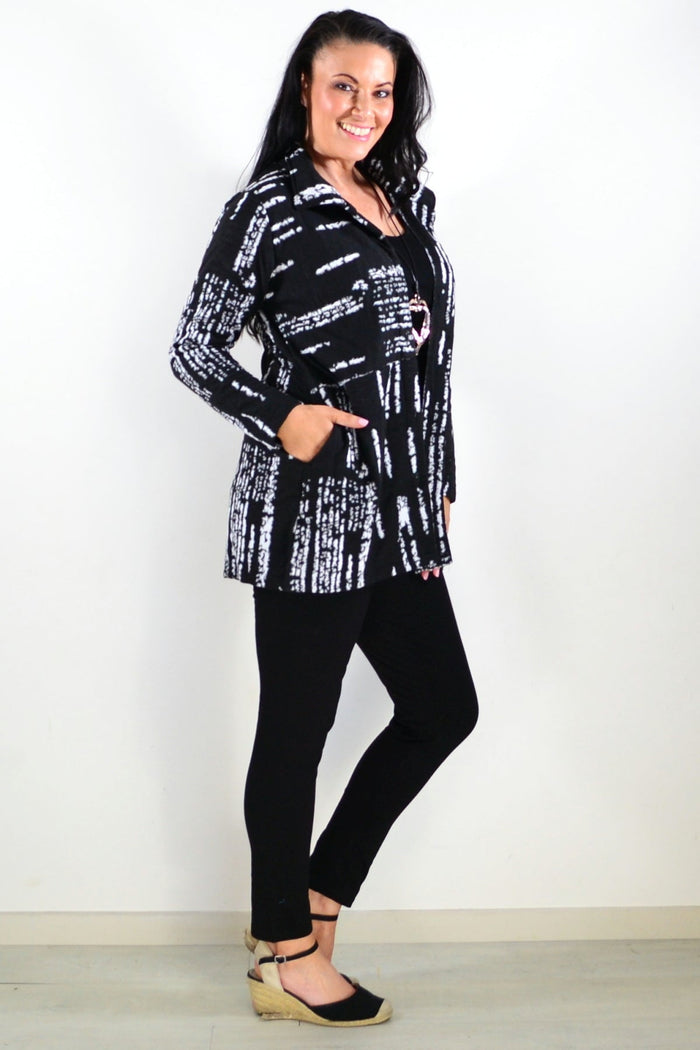 Black and white Hourglass shirt jacket tunic with a classic collar and button-front design, shown on a hanger.