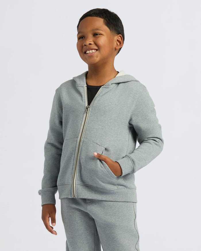 Boy wearing Boys' Medium Heather Gray Fleece Full Zip Hoodie, smiling.