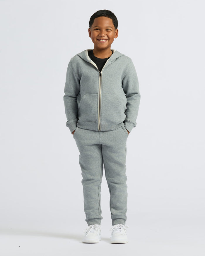 Boy wearing Boys' Medium Heather Gray Fleece Full Zip Hoodie, smiling.
