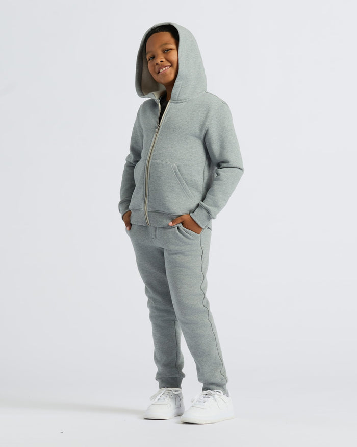 Boy wearing Boys' Medium Heather Gray Fleece Full Zip Hoodie, smiling.