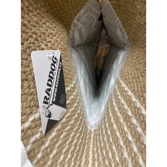 Close-up interior view of RADDOG jute sleeve showing padded bite channel, durable lining, and attached product tag.