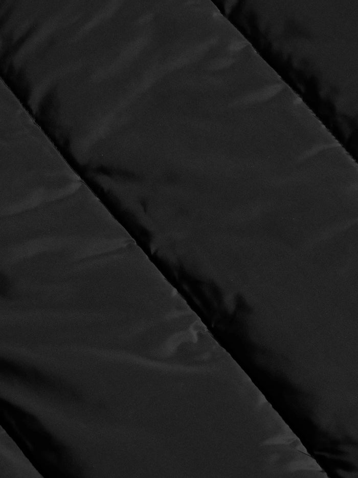 Close-up texture of the black puffer jacket's quilted nylon fabric – Wam Denim.