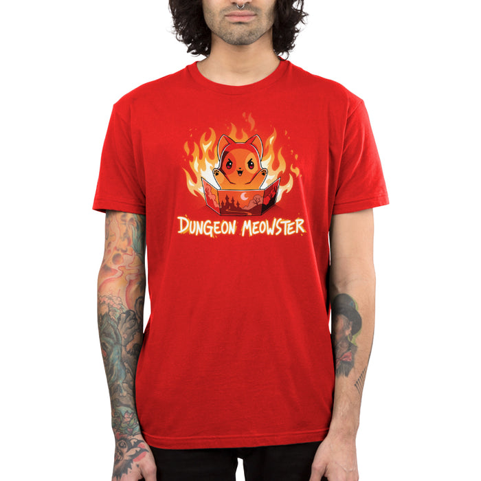 Premium Cotton T-shirt_TeeTurtle Dungeon Meowster garnet red apparel featuring a cartoon red cat surrounded by flames with an evil look on its face  holding a book that has a castle, moon and trees on the cover with Dungeon Meowster written underneath.
