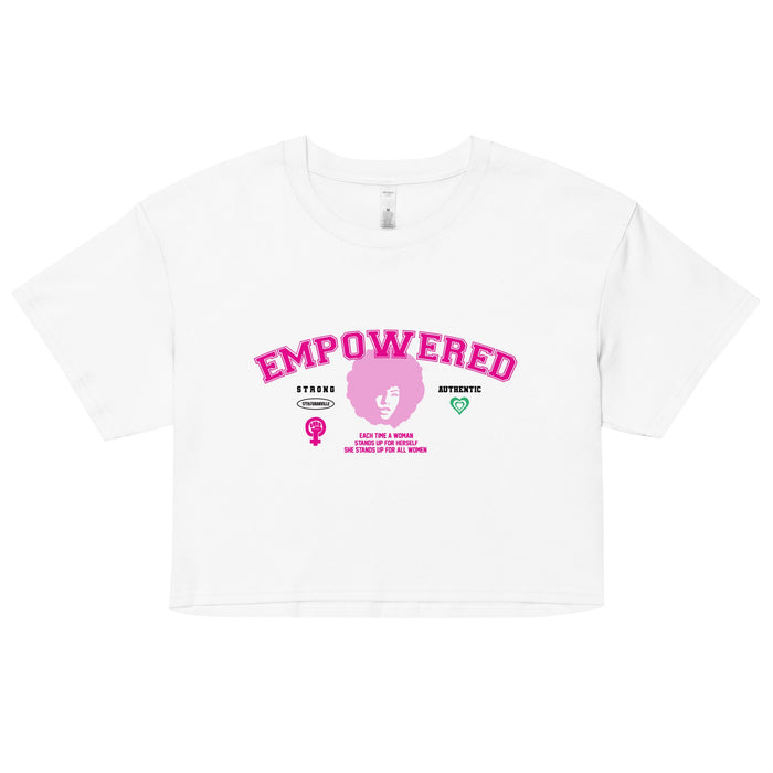 The Empowered Crop Top by 17th & Granville showcases pink EMPOWERED lettering on a white background. Beneath it, there's a stylized female symbol with a raised fist, accompanied by the words STRONG and ATHLETIC. Made from premium fabric by this black-owned brand, the top features extra symbols to amplify its striking design.