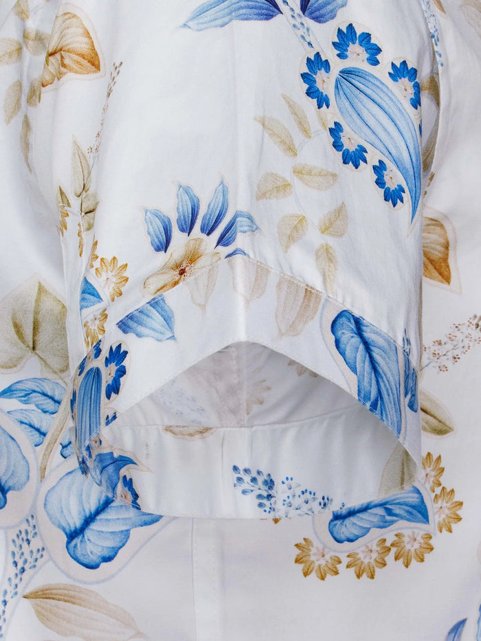 Close-up of short sleeve detail with blue and beige floral pattern on white fabric – Wam Denim.