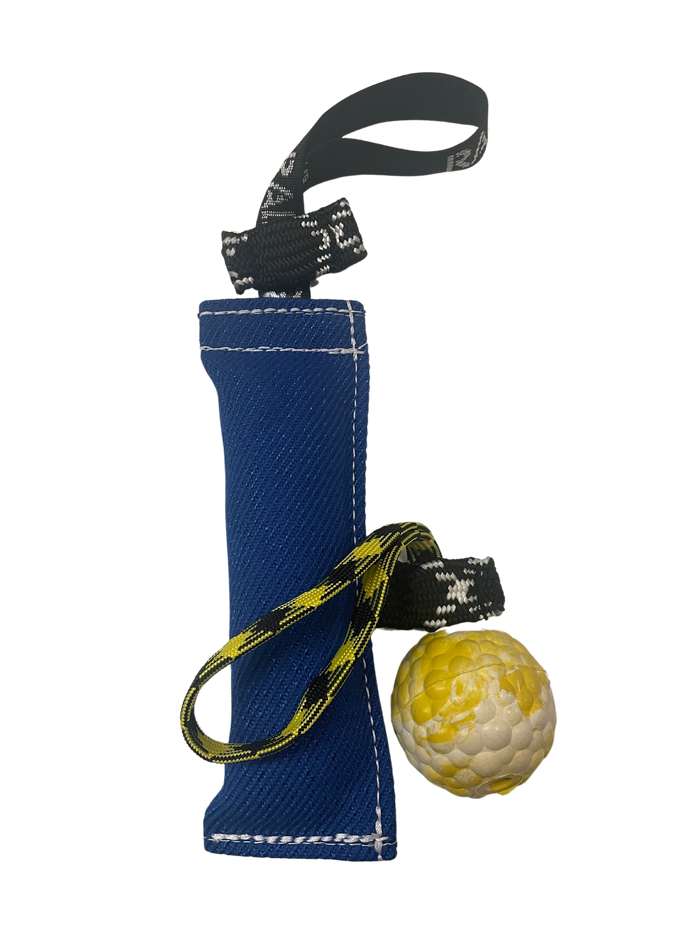Blue dog training tug with reinforced stitching, attached rope handles, and a yellow foam ball for interactive reward and retrieval training.