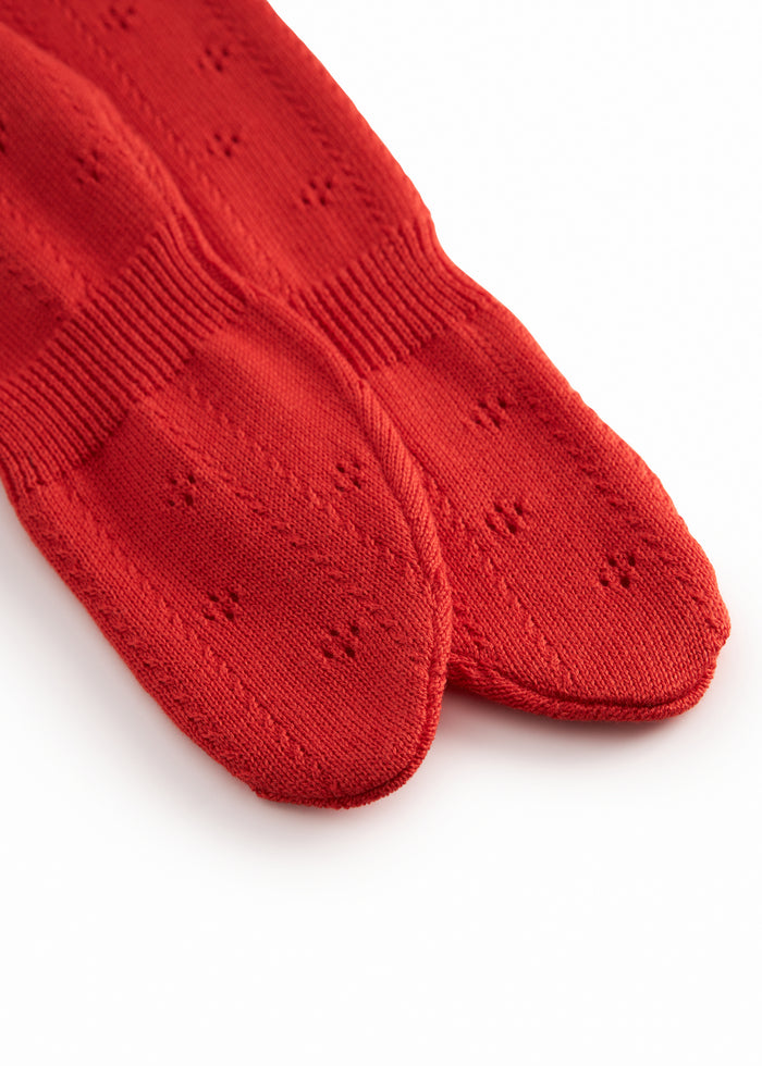 Red baby socks with feet and a fine hole pattern.
