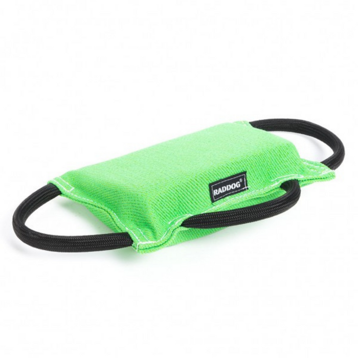 Neon green padded dog training bite tug with a textured fabric surface, white stitching along the edges, a black “RADDOG” label on the side, and two black rope handles on each end, displayed against a light background.