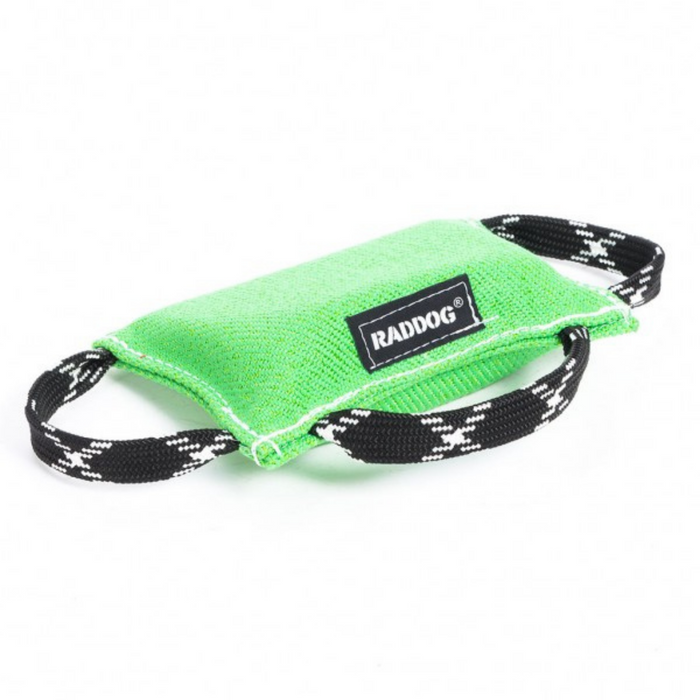 Light green dog training bite wedge made of durable textured fabric with reinforced white stitching and two black-and-white patterned handles, featuring a “RADDOG” label, isolated on a white background.