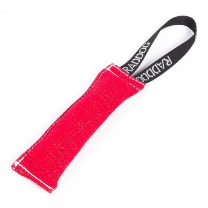 Red dog training tug toy made of durable fabric with white stitching and a black loop handle labeled “RADDOG,” isolated on a white background.
