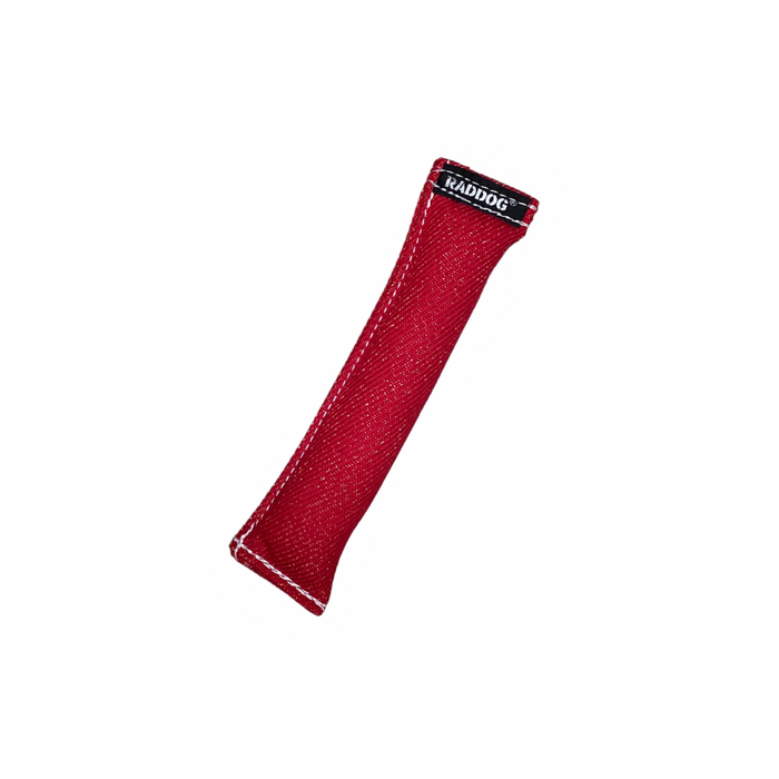 Red cylindrical dog training tug made of durable textured fabric with reinforced stitching and a black “RADDOG” label on one end.