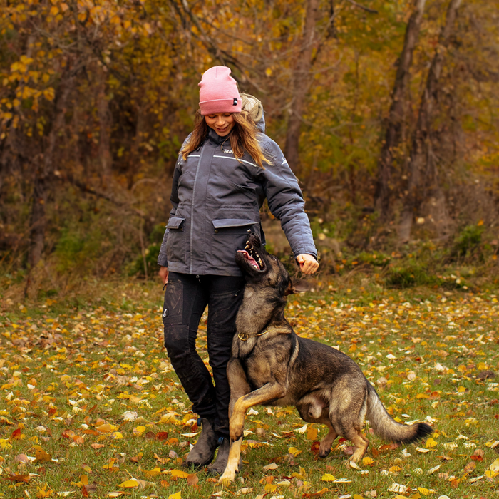 A female dog walker enjoying time outside with her dog wearing her new Ruffdog winter dog trainer jacket
