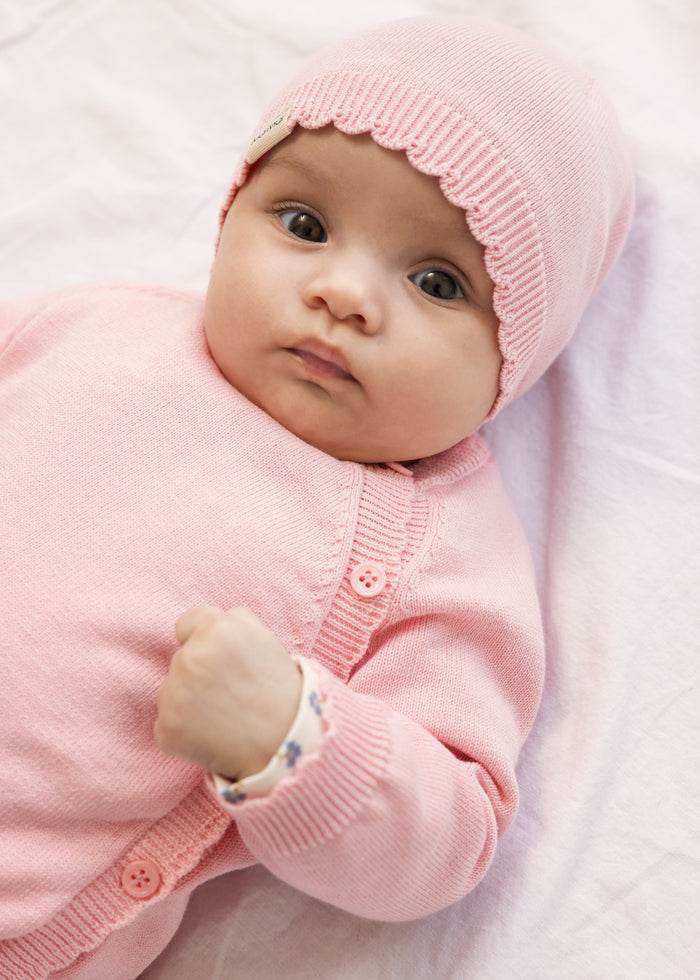 Pink sweater jumpsuit with hood and snap closure for baby